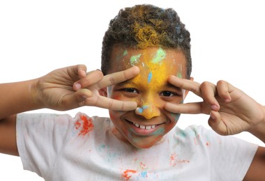 Photo of African American boy covered with colorful powder dyes on white background. Holi festival celebration