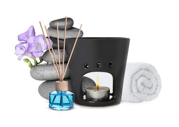 Image of Beautiful composition with rolled towel, aroma lamp and stacked stones on white background. Spa therapy
