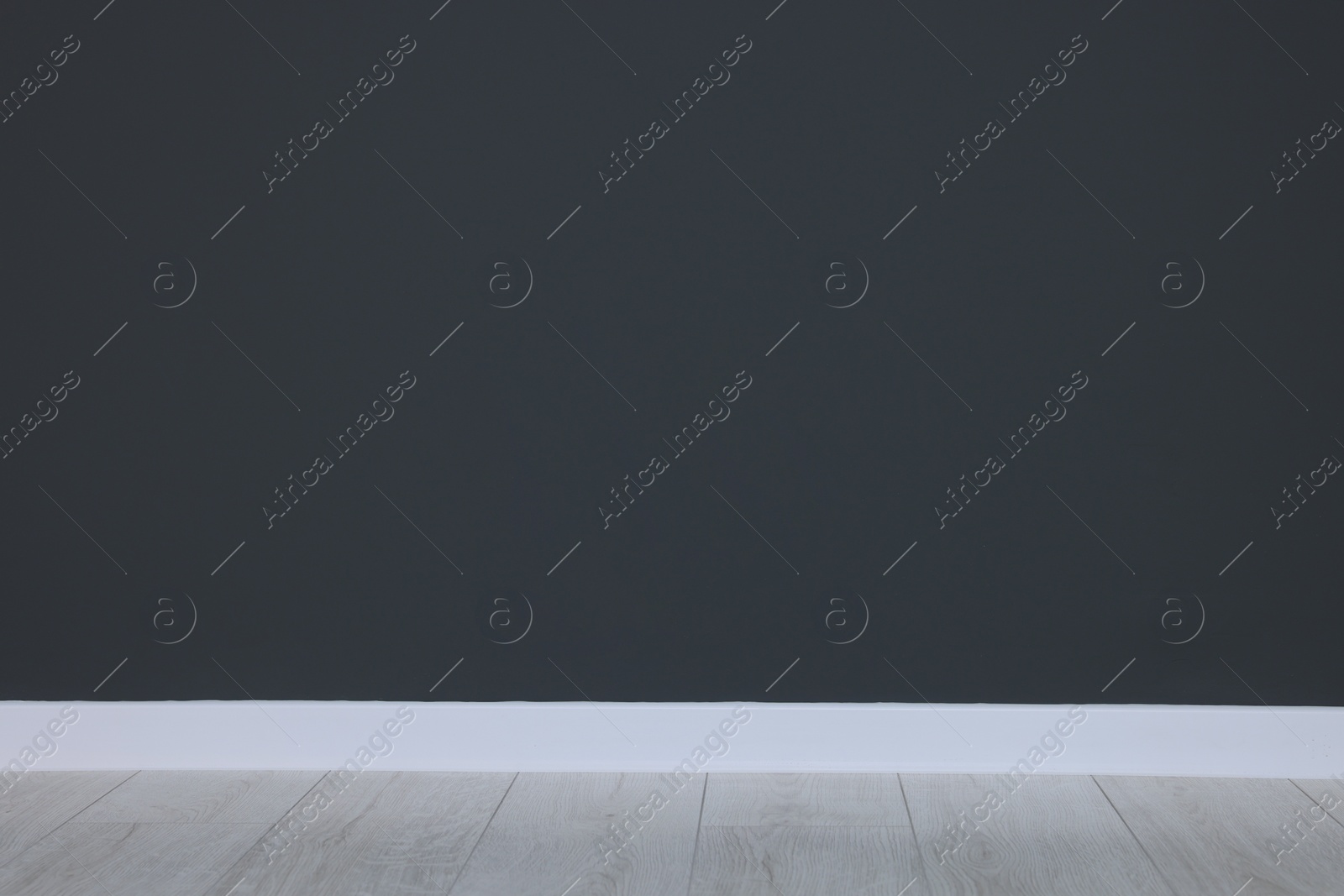 Photo of Beautiful dark grey wall and wooden floor in clean empty room