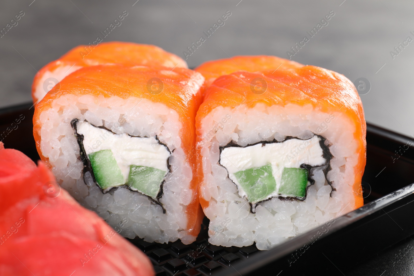 Photo of Tasty sushi rolls in box, closeup. Food delivery service