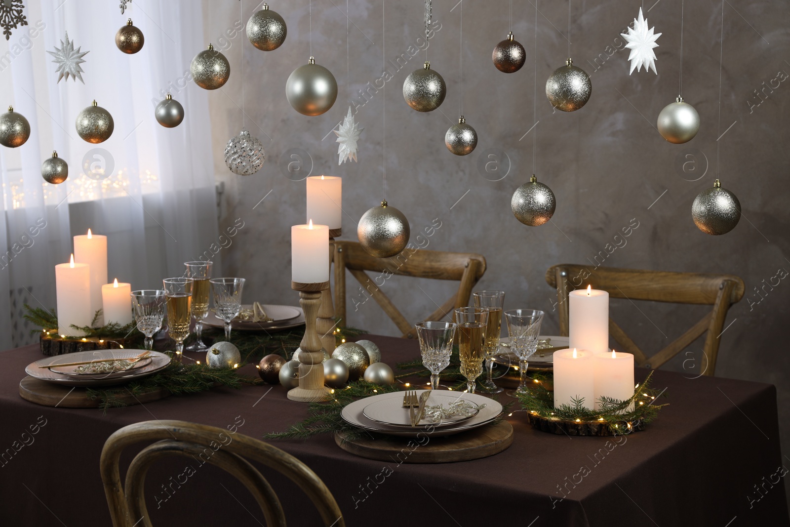 Photo of Christmas table setting with burning candles and festive decor