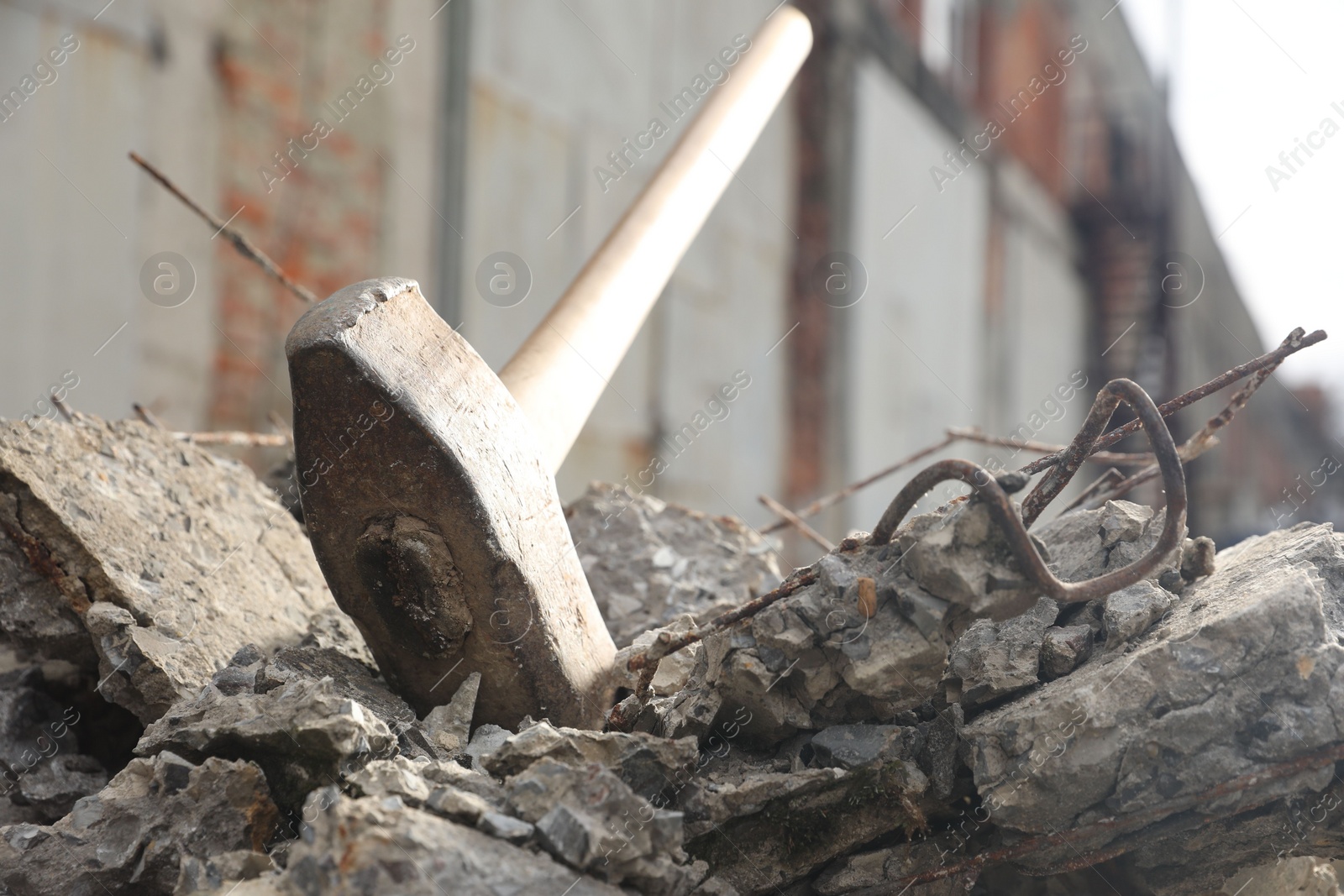 Photo of Sledgehammer on pile of broken stones outdoors, closeup