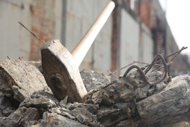 Sledgehammer on pile of broken stones outdoors, closeup