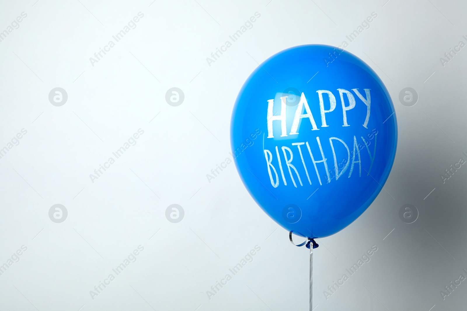 Photo of Blue balloon with words HAPPY BIRTHDAY on white background