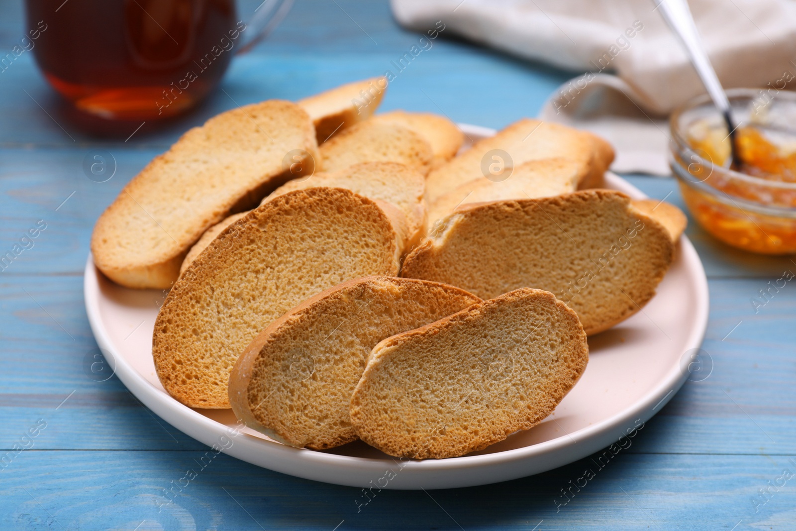 Photo of Plate of hard chuck crackers on light blue wooden table