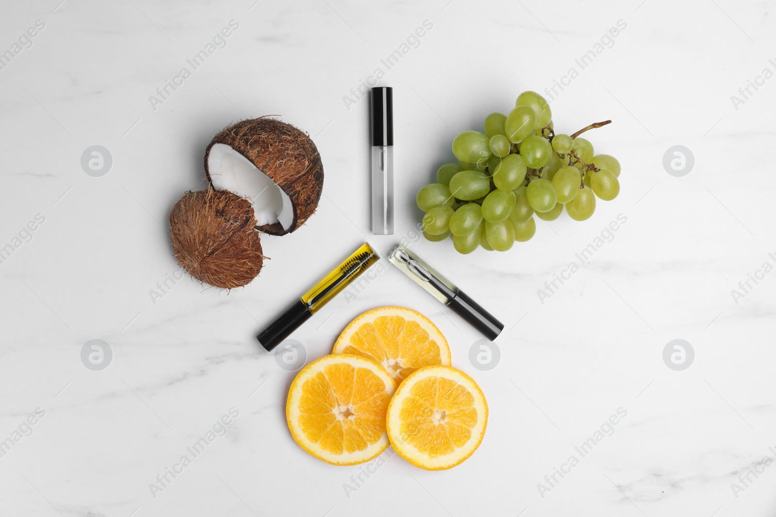 Photo of Flat lay composition with different eyelash oils and fresh fruits on white marble table