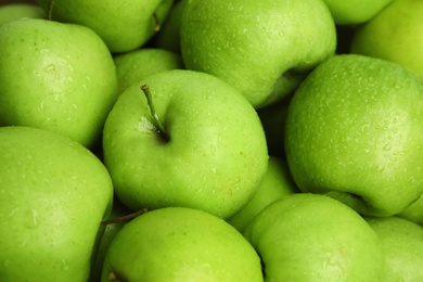 Photo of Fresh ripe green apples with water drops as background, closeup view