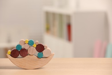 Photo of Wooden balance toy on table indoors, closeup. Space for text. Children's development