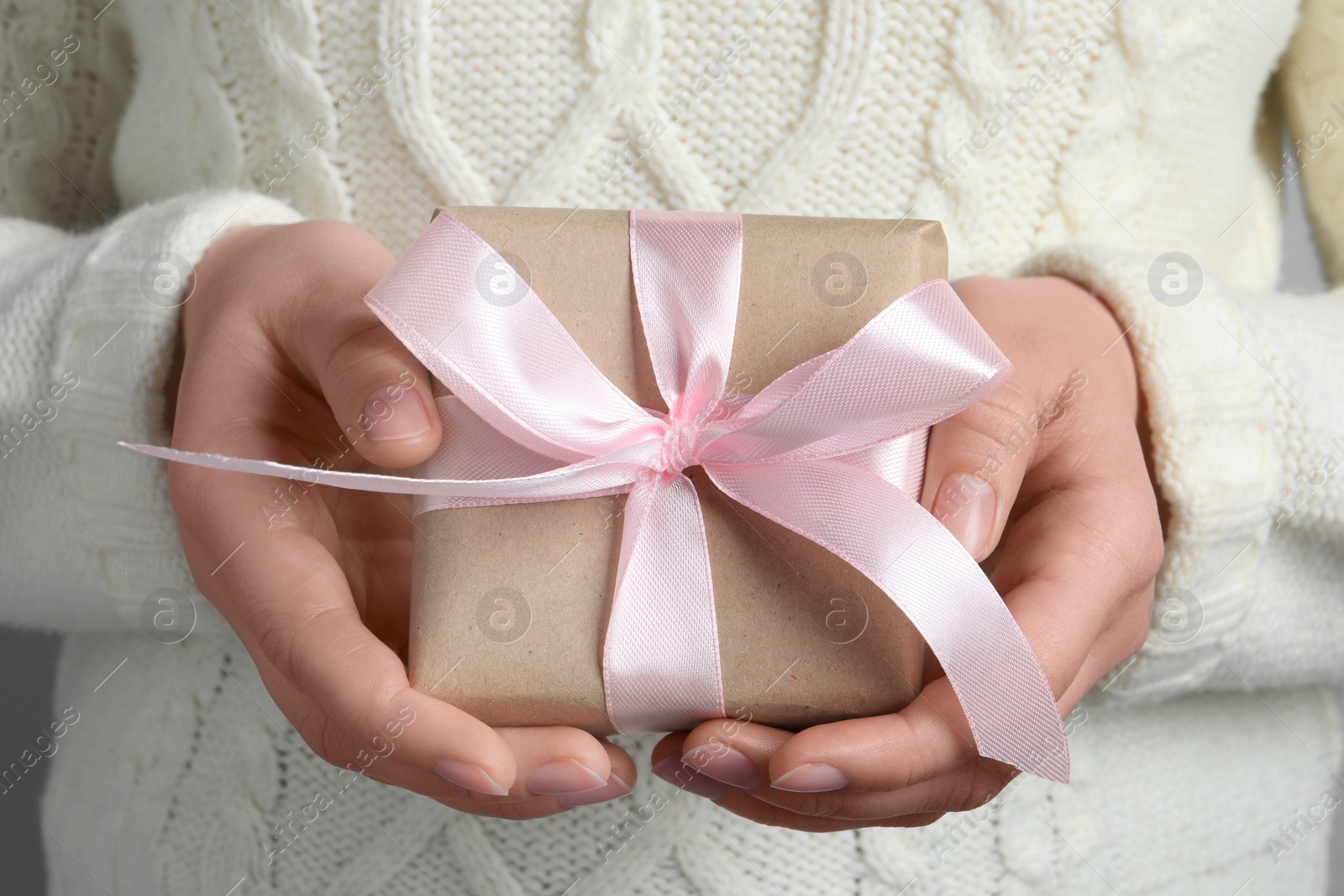 Photo of Woman holding gift box with pink bow, closeup