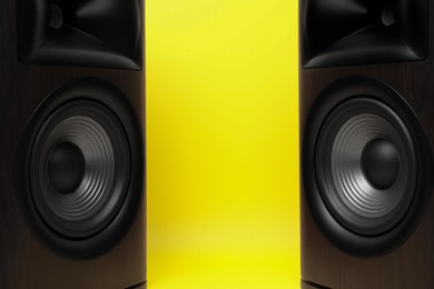 Photo of Wooden sound speakers on yellow background, closeup. Space for text