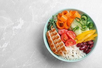 Photo of Tasty rice with beans on light grey marble table, top view. Space for text