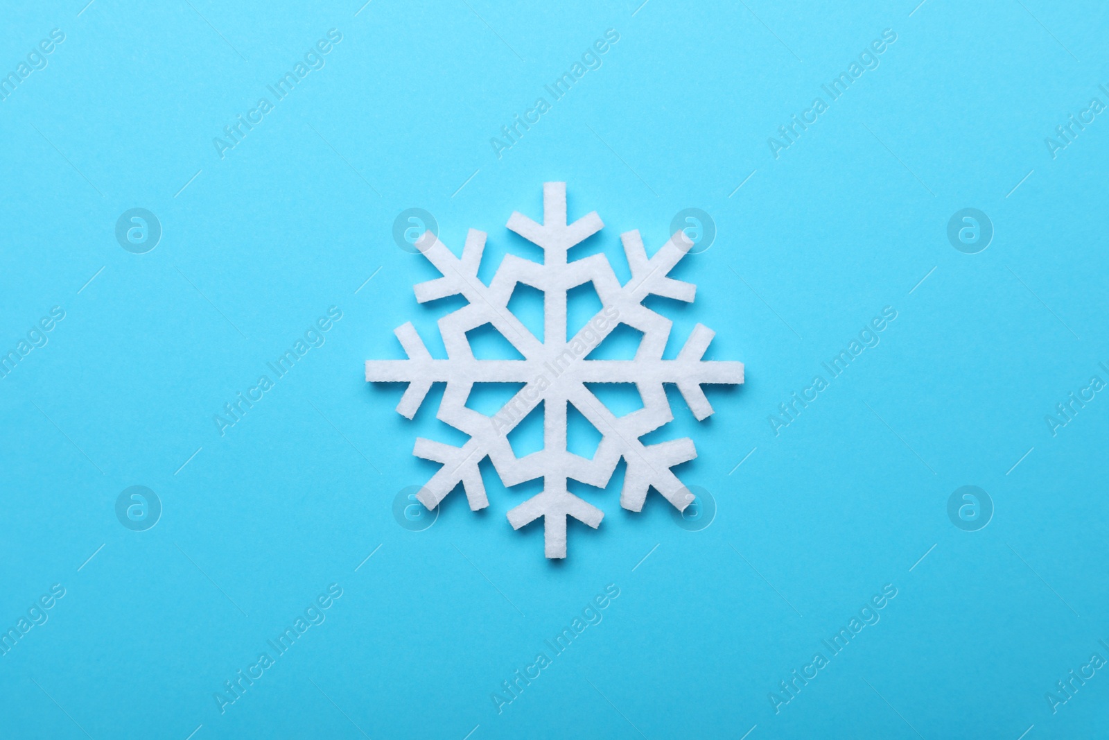 Photo of Beautiful decorative snowflake on light blue background, top view