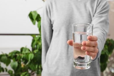 Photo of Woman holding glass of pure water, closeup