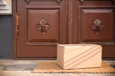 Photo of Delivered parcel on door mat near entrance. Space for text