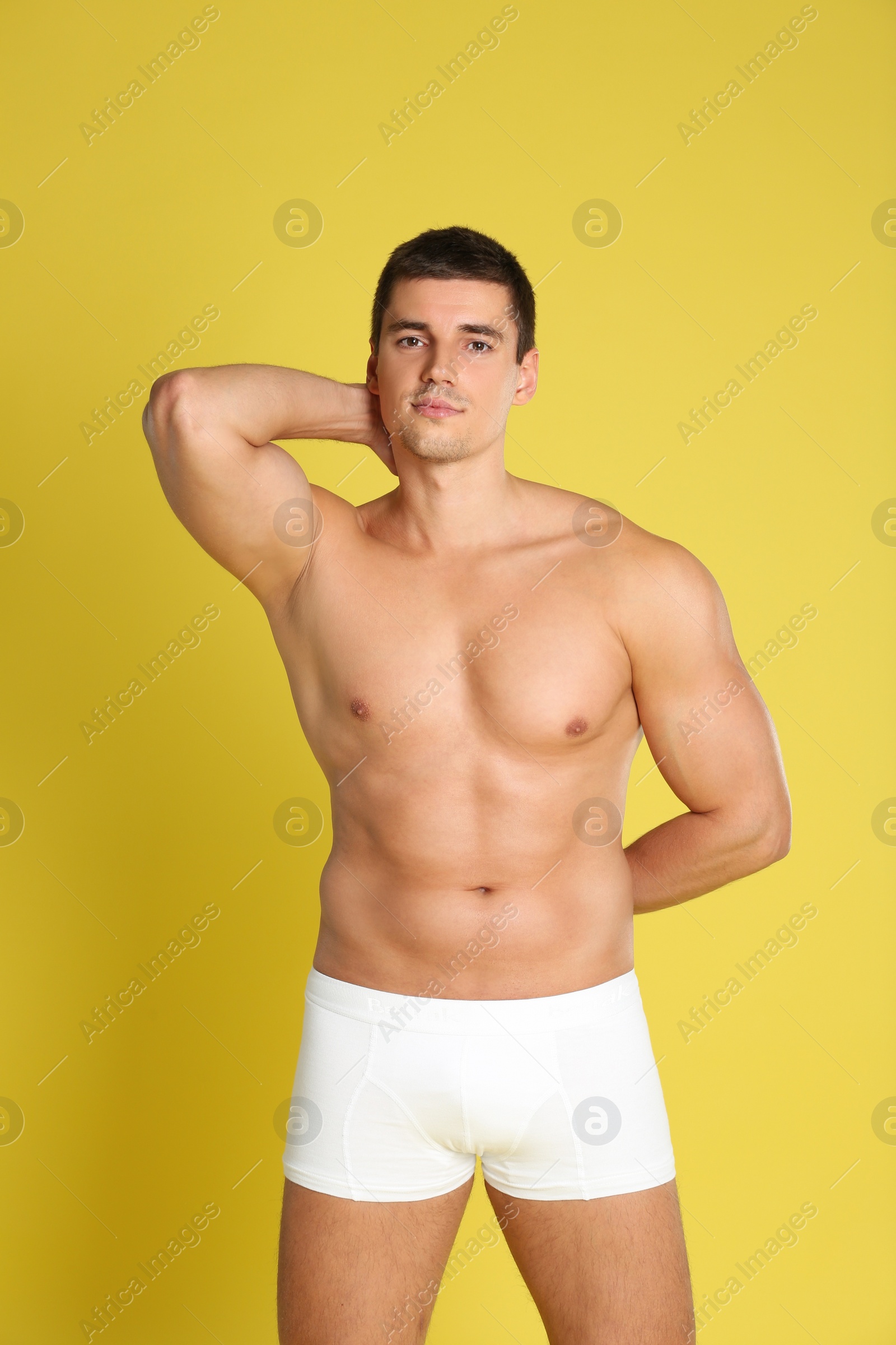 Photo of Man with sexy body on yellow background