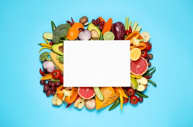 Photo of Flat lay composition with fresh organic vegetables, fruits and blank card on light blue background. Space for text