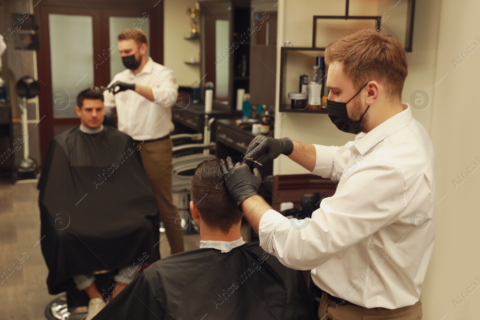 Photo of Professional hairdresser making stylish haircut in salon