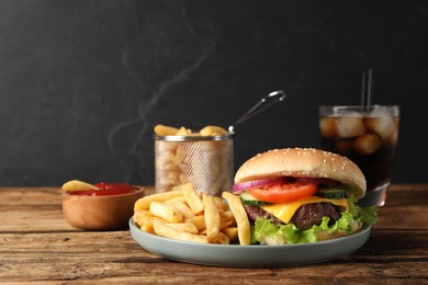 Photo of Delicious burger, soda drink and french fries served on wooden table