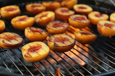 Photo of Modern grill with tasty cut peaches, closeup