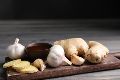 Photo of Fresh garlic and other natural cold remedies on light grey wooden table. Space for text