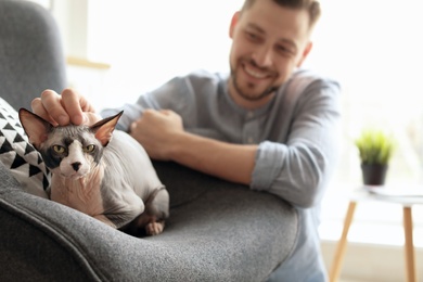 Photo of Young man with cute cat at home