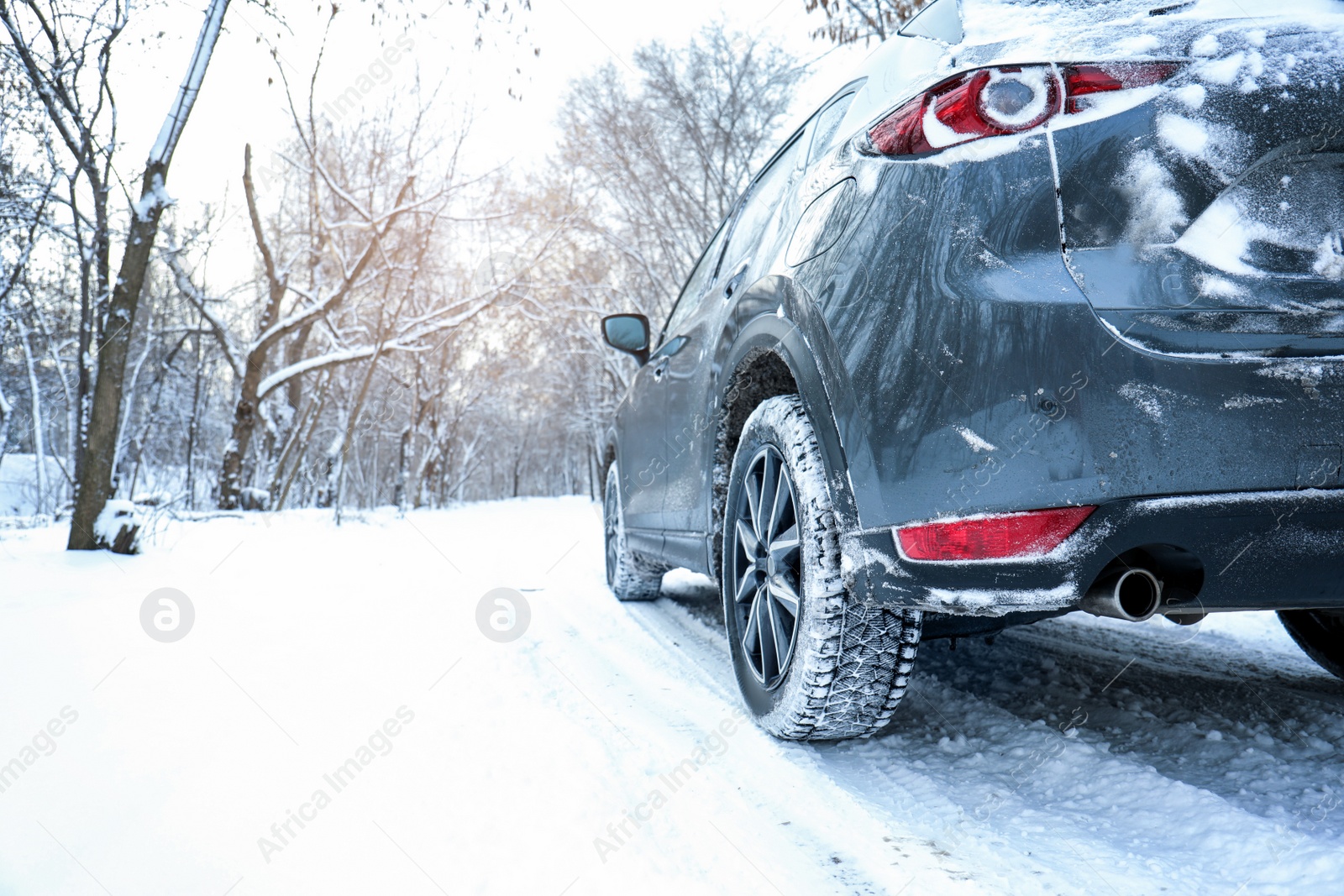 Photo of Snowy country road with car on winter day. Space for text