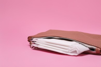 Photo of Brown bag with menstrual pads on pink background