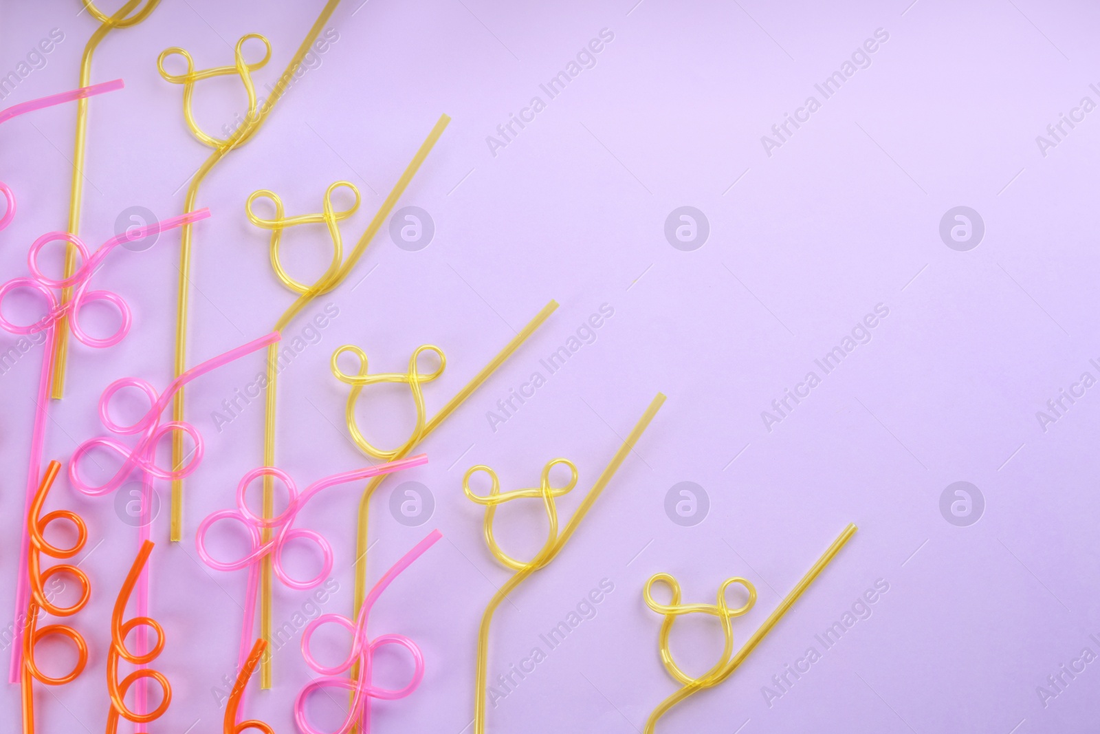 Photo of Colorful plastic drinking straws on violet background, flat lay. Space for text