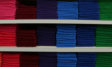 Stacks of colourful towels on store shelves