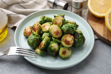 Photo of Delicious roasted Brussels sprouts on grey table, closeup