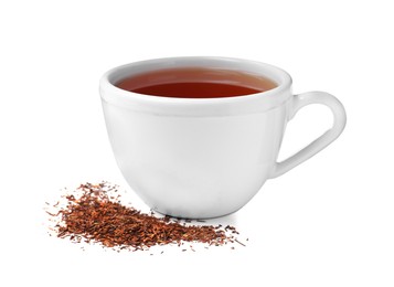 Photo of Aromatic rooibos tea in ceramic cup and scattered dry leaves on white background