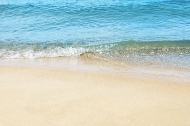 View of sea water and beach sand on sunny day