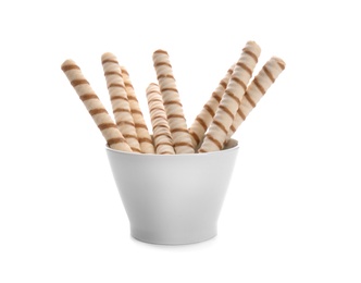 Photo of Bowl with tasty wafer roll sticks on white background. Crispy food