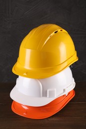 Photo of Hard hats on wooden table. Safety equipment