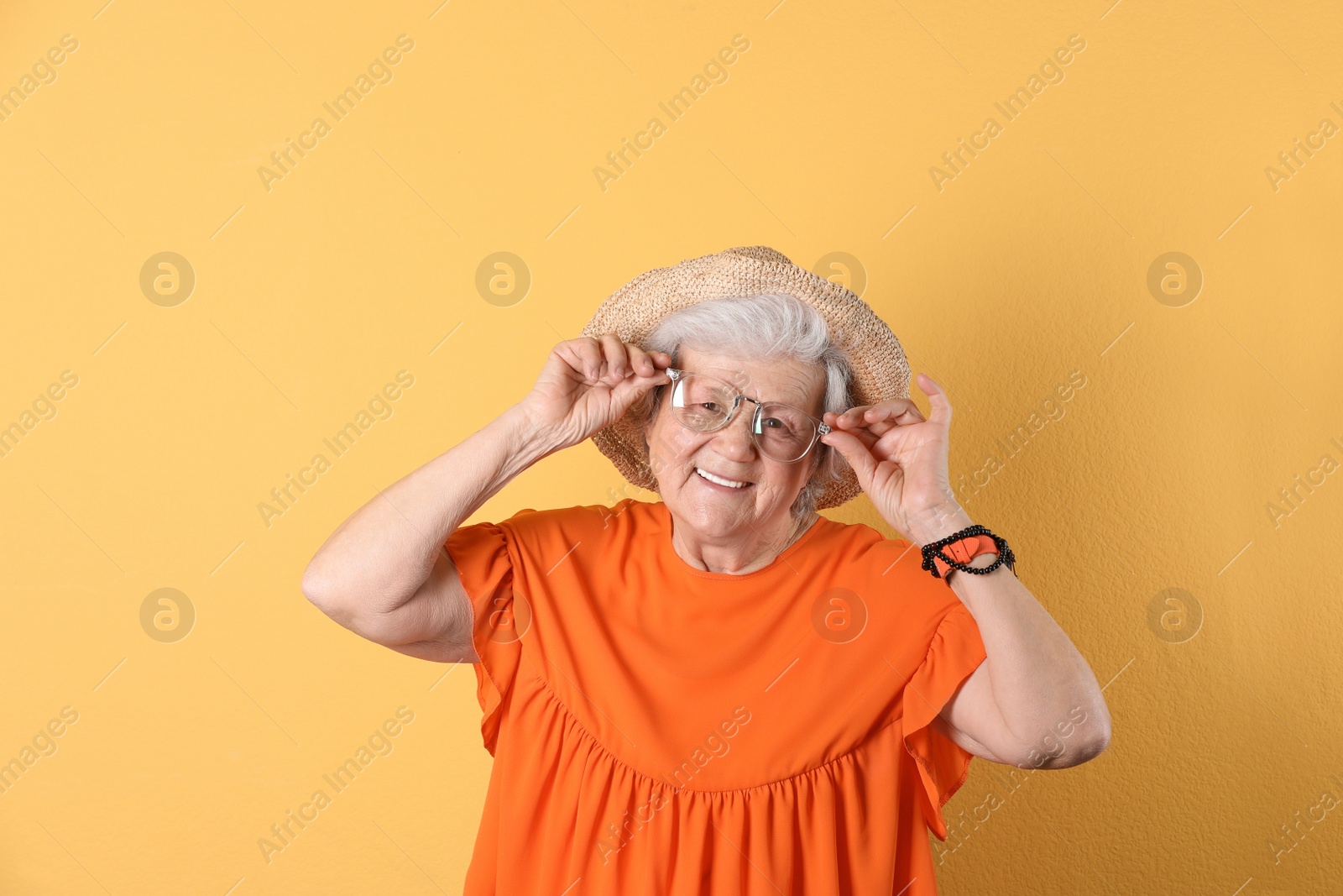 Photo of Portrait of cool grandmother on color background