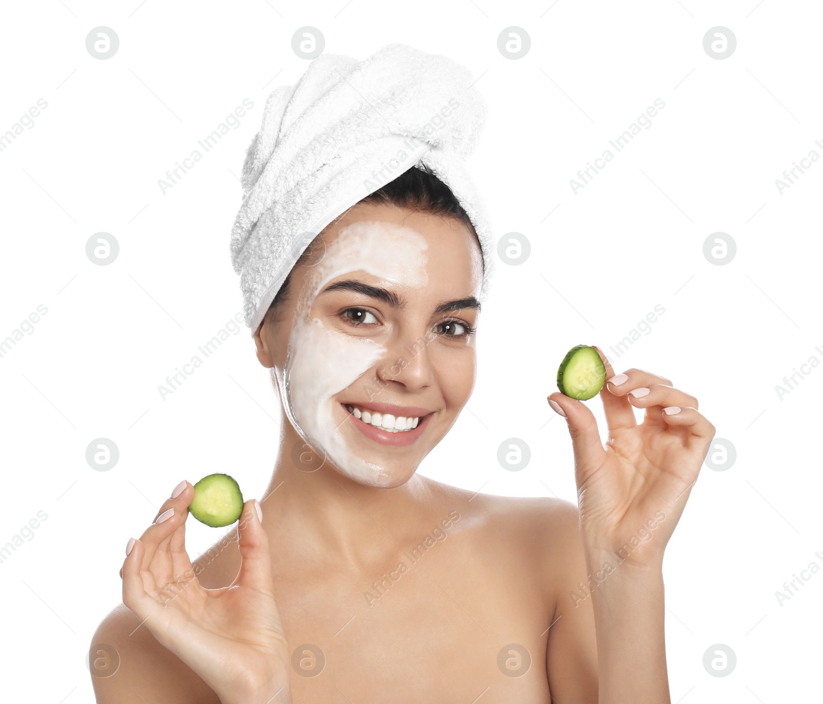 Photo of Happy young woman with organic mask on her face holding cucumber slices against white background