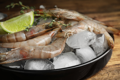 Photo of Fresh raw shrimps with ice on table, closeup