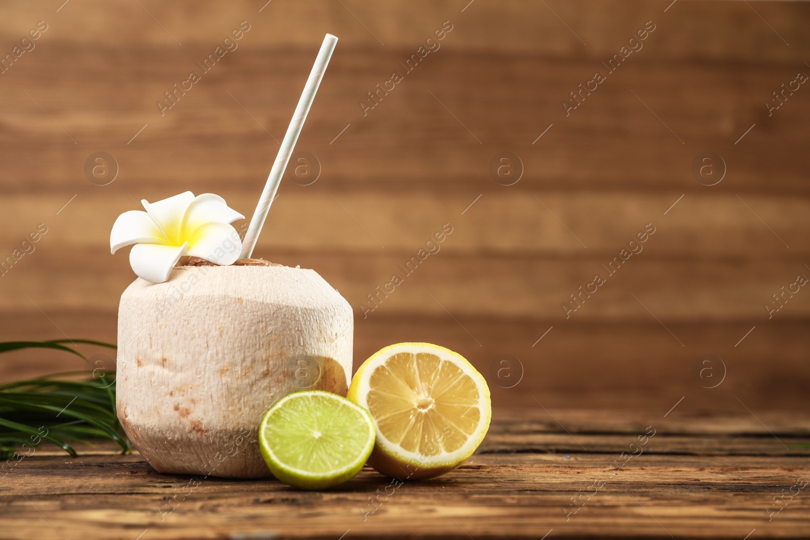 Photo of Open fresh coconut and citrus fruits on wooden table. Space for text