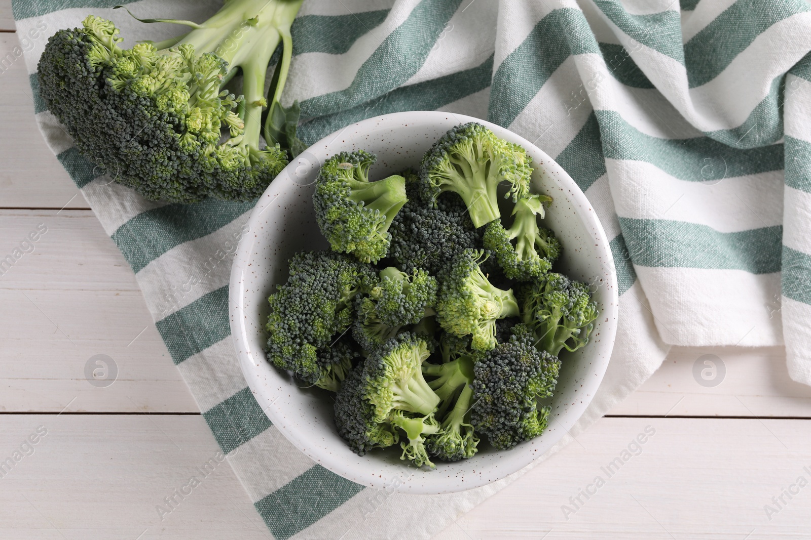 Photo of Fresh raw broccoli on white wooden table, flat lay