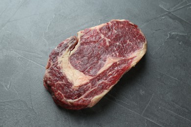 Photo of Piece of raw beef meat on grey table, above view