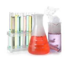 Photo of Laboratory glassware and tubes with colorful liquids isolated on white. Chemical reaction