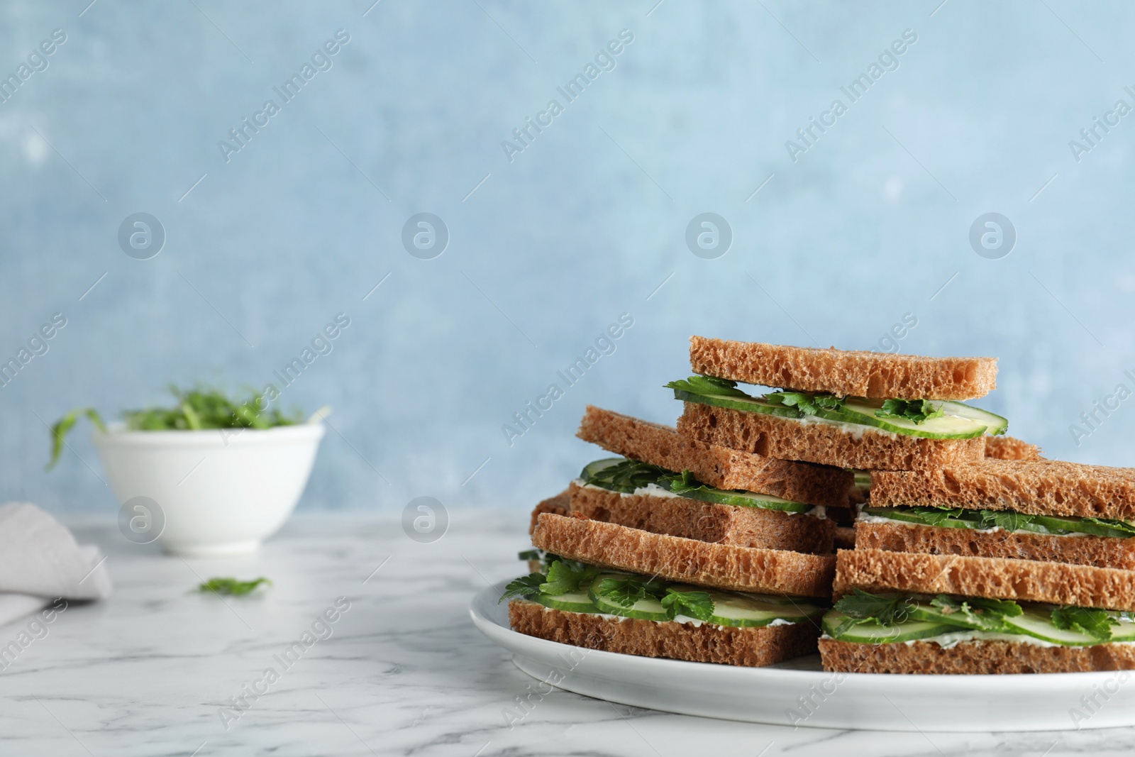 Photo of Plate with traditional English cucumber sandwiches on table. Space for text