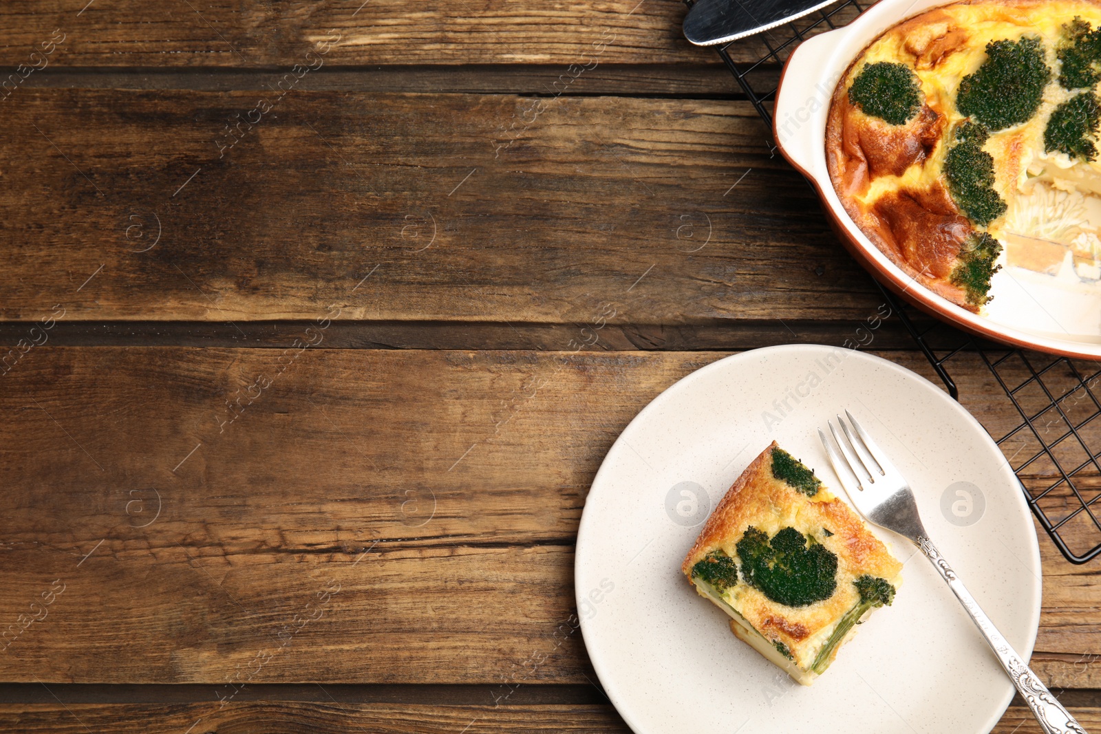 Photo of Tasty broccoli casserole served on wooden table, flat lay. Space for text