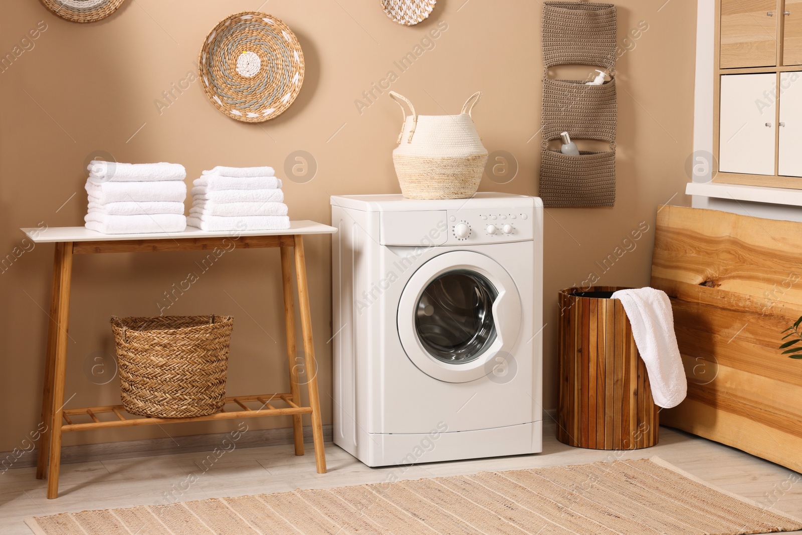 Photo of Stylish laundry room with modern washing machine. Interior design