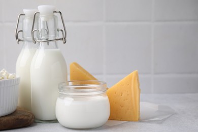 Photo of Different fresh dairy products on light table, closeup. Space for text