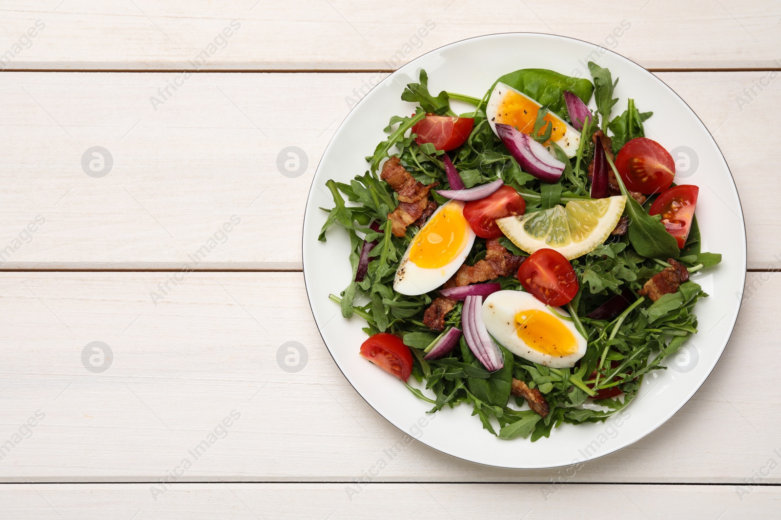 Photo of Delicious salad with boiled eggs, vegetables and bacon on white wooden table, top view. Space for text