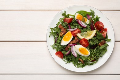 Photo of Delicious salad with boiled eggs, vegetables and bacon on white wooden table, top view. Space for text