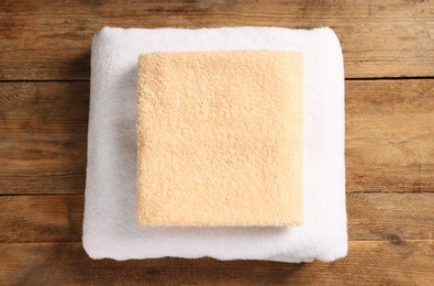 Photo of Soft folded terry towels on wooden table, top view
