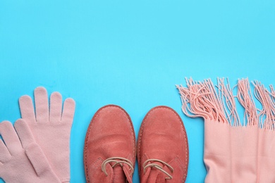 Photo of Flat lay composition with warm clothes on light blue background. Space for text