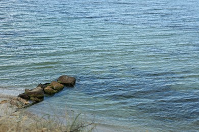 Photo of Picturesque view of sandy beach with stones and beautiful sea